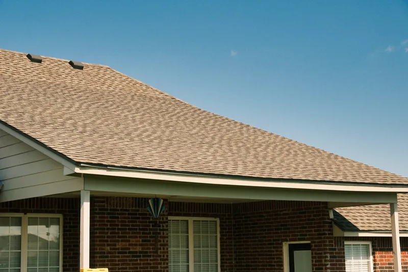 Finished shingle roof above a two car garage on a brick home