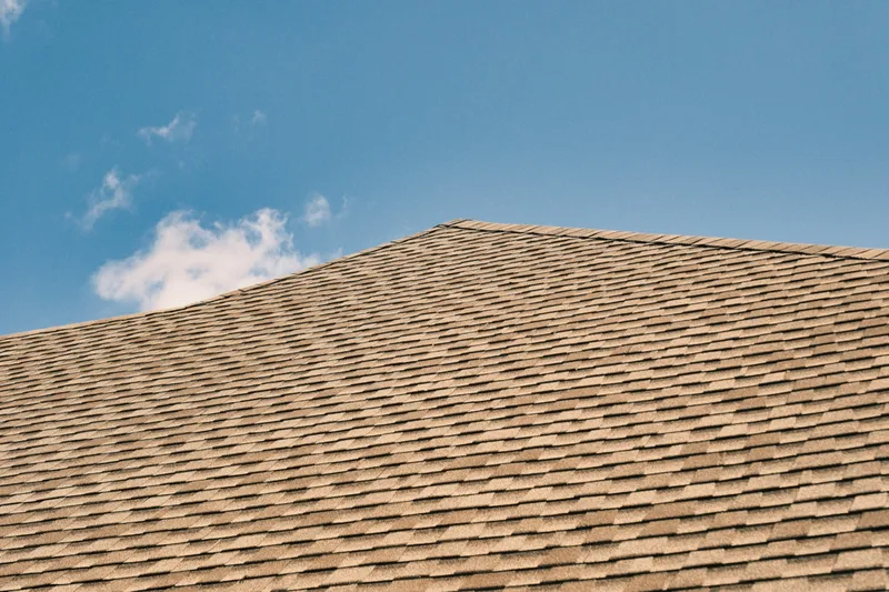Architectural shingle roof and ridge under an open sky