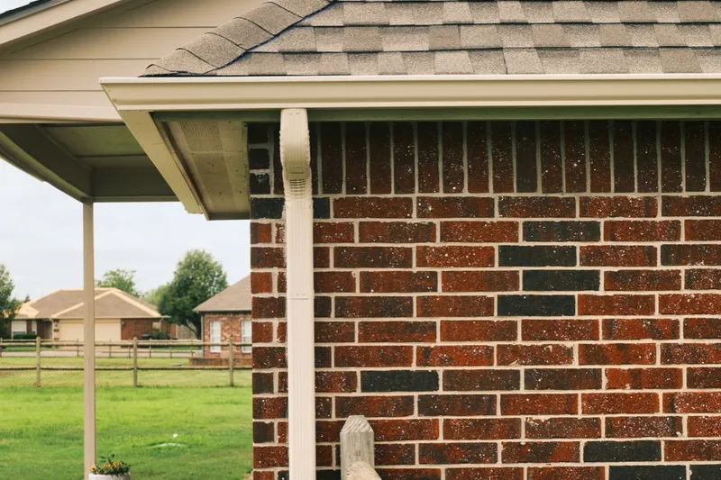 Seamless gutter and downspout on the corner of a brick home
