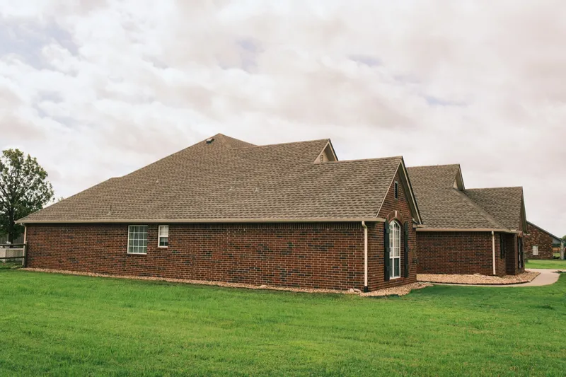 Side elevation of a brick home with a completed shingle roof