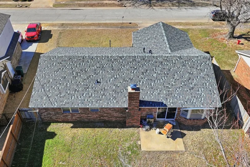 Overhead view of a finished shingle roof on a single story brick home