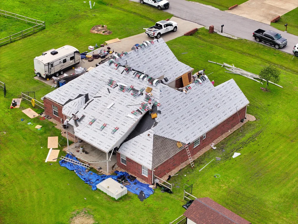 Aerial view of an R&R Roofing crew mid roof replacement on an Oklahoma home