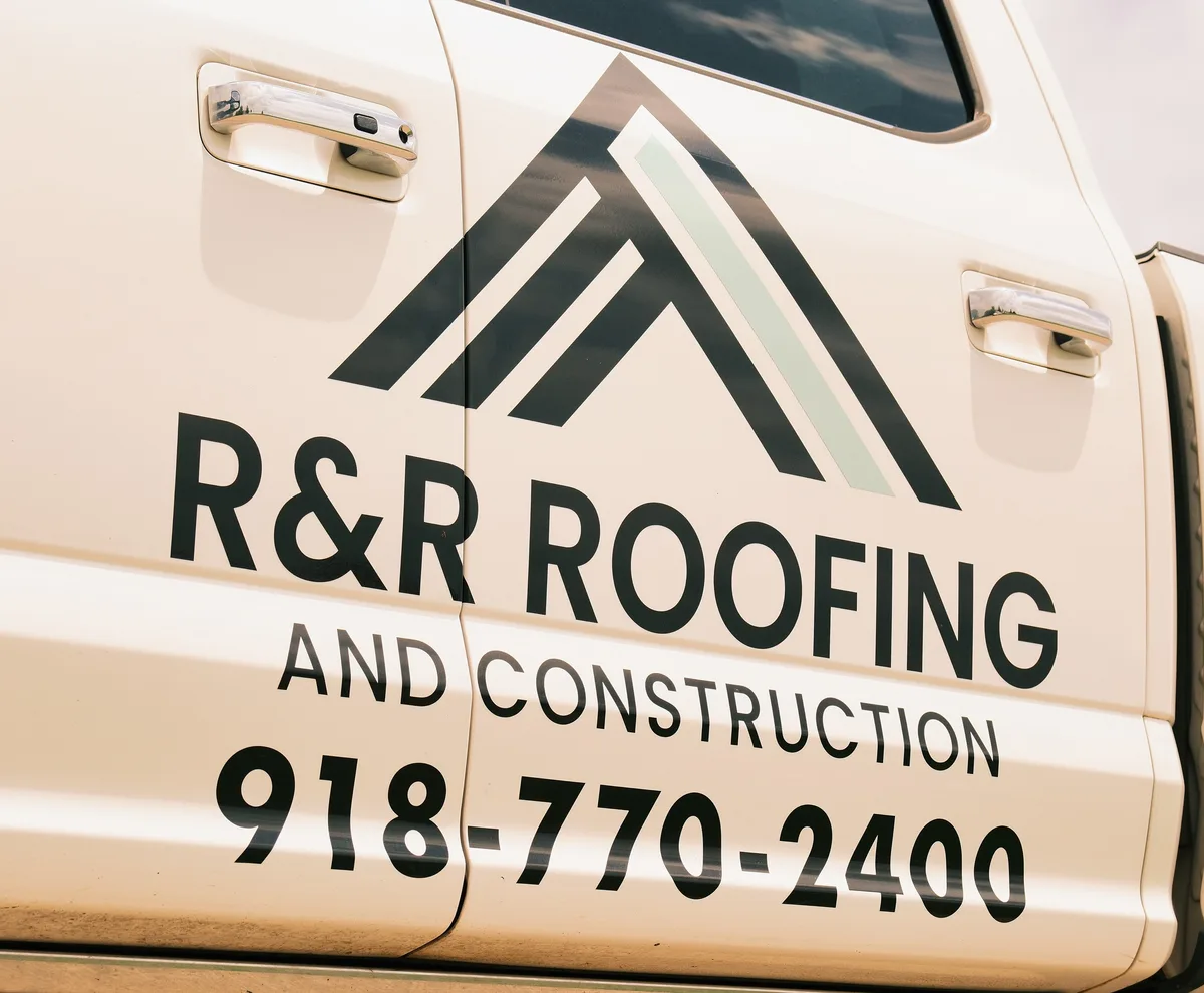 R&R Roofing and Construction truck door showing the company logo and phone number